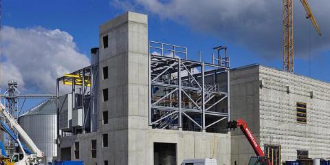 Construction site with concrete building and construction cranes.